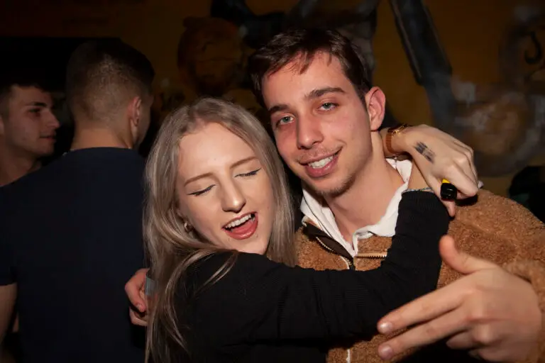 A blond girl holding a smiling guy in her arms