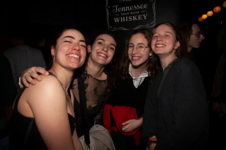 Four smiling girlfriends posing for the camera