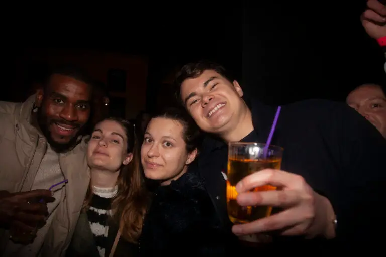 A group of four smiling friends posing for the camera